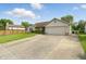 Front exterior of a single-story home featuring a spacious driveway and well-kept lawn at 2145 W Autumn Ln, Columbus, IN 47201