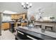 Bright kitchen featuring wood cabinetry, black countertops, stainless steel appliances, and an eat-in kitchen table at 2145 W Autumn Ln, Columbus, IN 47201