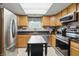 Updated kitchen features stainless steel appliances, wood cabinets, black countertops, and a movable island at 2145 W Autumn Ln, Columbus, IN 47201