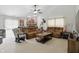 Spacious living room with plush brown sofas, a brick fireplace, and a ceiling fan at 2145 W Autumn Ln, Columbus, IN 47201