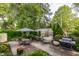 Picturesque backyard patio with dining sets, lush greenery, a grill, and a greenhouse at 224 N Pennsylvania St, Greenfield, IN 46140