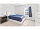 Cozy bedroom with a queen-sized bed, dark wood nightstand, and a bright window at 2326 Gradison Cir, Indianapolis, IN 46214