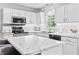 Bright, updated kitchen with white cabinets, marble countertops, stainless steel appliances, and an island with seating at 2326 Gradison Cir, Indianapolis, IN 46214