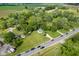 Aerial view of house with long front lawn bordering a busy two-lane road surrounded by trees and neighborhood at 2710 W State Road 38, Sheridan, IN 46069