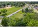 Aerial view of a grassy lot with a blue border, trees, and a road in a residential area at 2710 W State Road 38, Sheridan, IN 46069