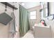 Neutral bathroom features updated vanity, modern fixtures, and a shower with a green curtain at 272 Jefferson St, Columbus, IN 47201