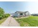 Charming home with white siding, stone accents, and a long gravel driveway at 272 Jefferson St, Columbus, IN 47201