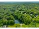 Scenic aerial view of a lake surrounded by lush greenery and mature trees, perfect for nature lovers at 2805 Fox E Ct, Martinsville, IN 46151
