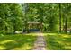Stone path leads to outdoor gazebo featuring covered hot tub in wooded backyard at 2805 Fox E Ct, Martinsville, IN 46151