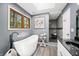 Bright bathroom with a freestanding tub, wood trim window, and tiled shower, offering spa-like comfort at 2805 Fox E Ct, Martinsville, IN 46151