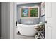 Beautiful bathroom featuring a stand-alone tub beneath a wood trim window, creating a relaxing space at 2805 Fox E Ct, Martinsville, IN 46151