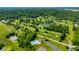 Aerial view featuring a golf course, pond, pool, tennis courts, and lush greenery, great for recreation at 2805 Fox E Ct, Martinsville, IN 46151