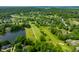 High aerial view of a golf course and pond surrounded by lush greenery and residential homes in the distance at 2805 Fox E Ct, Martinsville, IN 46151