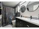 Nicely renovated bathroom featuring double sinks, two round mirrors and patterned shower curtain at 2887 Ludwig Dr, Indianapolis, IN 46239