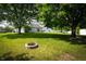 Large backyard with a fire pit and mature trees offering shade and privacy at 2905 Inverrary Ct, Indianapolis, IN 46234