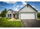 Charming one story home featuring a two car garage, neat landscaping and a red front door at 2905 Inverrary Ct, Indianapolis, IN 46234