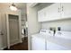 Laundry area with white washer and dryer, white cabinets, and a glimpse of the kitchen at 2905 Inverrary Ct, Indianapolis, IN 46234