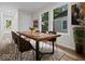 Dining room features a rustic wood table, six chairs, a neutral rug, art and natural light at 31 Mckenzie St, Shelbyville, IN 46176
