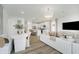 Bright, open living room featuring wood floors and an open concept kitchen with a central island and modern appliances at 3142 Balsamroot Rd, Greenwood, IN 46143