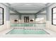 Beautiful indoor pool with spa and access steps and bright lighting, surrounded by greenery at 3142 Balsamroot Rd, Greenwood, IN 46143