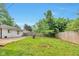 Back yard with a wooden fence, shed, grass, and mature trees at 3242 Welch Dr, Indianapolis, IN 46224