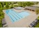 Community swimming pool with a large pool deck area, chairs, and surrounding trees and lush landscaping at 3876 Kegler Way, Carmel, IN 46074