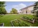 Spacious backyard with a patio, raised garden beds, and mature trees enhancing the landscape at 3876 Kegler Way, Carmel, IN 46074
