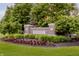 Inviting community entrance with a brick sign, manicured landscaping, and lush greenery at 3876 Kegler Way, Carmel, IN 46074