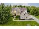 Aerial view of a two-story brick home with a manicured lawn, landscaping, and long driveway at 3876 Kegler Way, Carmel, IN 46074