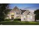 Elegant two-story brick home with manicured lawn and lush landscaping at twilight at 3876 Kegler Way, Carmel, IN 46074