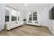 Cozy living room with wood floors, white sofas, decorative pillows, and large windows at 3876 Kegler Way, Carmel, IN 46074