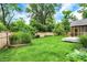 Spacious backyard with lush green lawn and a wooden fence and a screened in porch at 3940 E 57Th St, Indianapolis, IN 46220