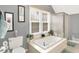 Bathroom with a soaking tub, large window, and tile floors at 3940 E 57Th St, Indianapolis, IN 46220