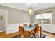 Bright dining room with modern light fixture, large windows, and dining table at 3940 E 57Th St, Indianapolis, IN 46220