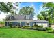 Charming blue home featuring a well-manicured lawn and vibrant flower beds at 3940 E 57Th St, Indianapolis, IN 46220