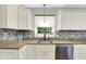Close-up of kitchen area showcasing granite countertops, stainless steel dishwasher, and tiled backsplash at 3940 E 57Th St, Indianapolis, IN 46220