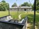 Spacious backyard with fire pit and string lights that leads up to a brick home with a chimney at 4343 W Fairview Rd, Greenwood, IN 46142