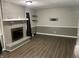Cozy living room features a brick fireplace, wood-look floors, and stylish shelving at 4343 W Fairview Rd, Greenwood, IN 46142