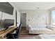 Cozy bedroom featuring wood-look floors, a white futon, a desk, and a window at 4605 Clairmont Dr, Columbus, IN 47203