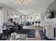 Open-concept living room with leather seating, a dining area, a breakfast bar, and hardwood floors at 4605 Clairmont Dr, Columbus, IN 47203