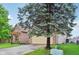 View of the home showing the side yard and two-car garage with large tree at 4933 Common Vista Way, Indianapolis, IN 46220