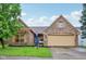 Charming brick home featuring a two-car garage, well-manicured lawn, and a bright blue front door at 4933 Common Vista Way, Indianapolis, IN 46220