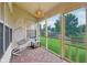 Relaxing screened porch features wood-look tile floor, hanging swing chair, and view of the lush backyard at 4933 Common Vista Way, Indianapolis, IN 46220