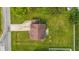 Aerial view of house with brown roof, concrete driveway, and green surroundings at 5030 E 800 N, Columbus, IN 47203