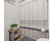 Bright bathroom corner showcasing a patterned shower curtain, a small wooden stool, and gray flooring at 5030 E 800 N, Columbus, IN 47203