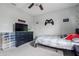 Comfortable bedroom with gaming-themed decor, featuring a large dresser with TV, a bed, and ceiling fan at 5030 E 800 N, Columbus, IN 47203