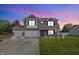 Two-story brick house with attached garage, green lawn and front porch at 5030 E 800 N, Columbus, IN 47203