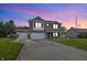 Two-story brick house with attached garage and manicured lawn at dusk at 5030 E 800 N, Columbus, IN 47203