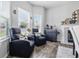 This living room features dual windows with blinds, two comfy chairs and fireplace at 5030 E 800 N, Columbus, IN 47203