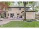 Backyard view of a brick home featuring a deck, patio furniture, and a well-maintained lawn at 518 Buckingham Dr, Indianapolis, IN 46208